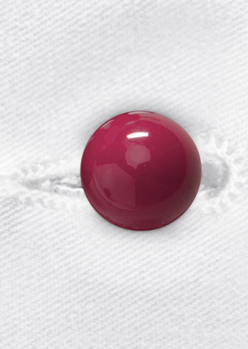 Bouton boule rouge sur une veste de cuisinier.